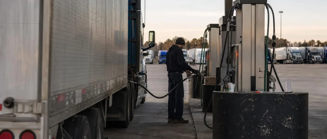 Diesel fuel island at a US truck stop with semi trucks in late afternoon